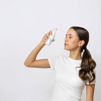 Young woman misting Skin Renew Toner on her face. Toner is perfect addition to her skincare routine.